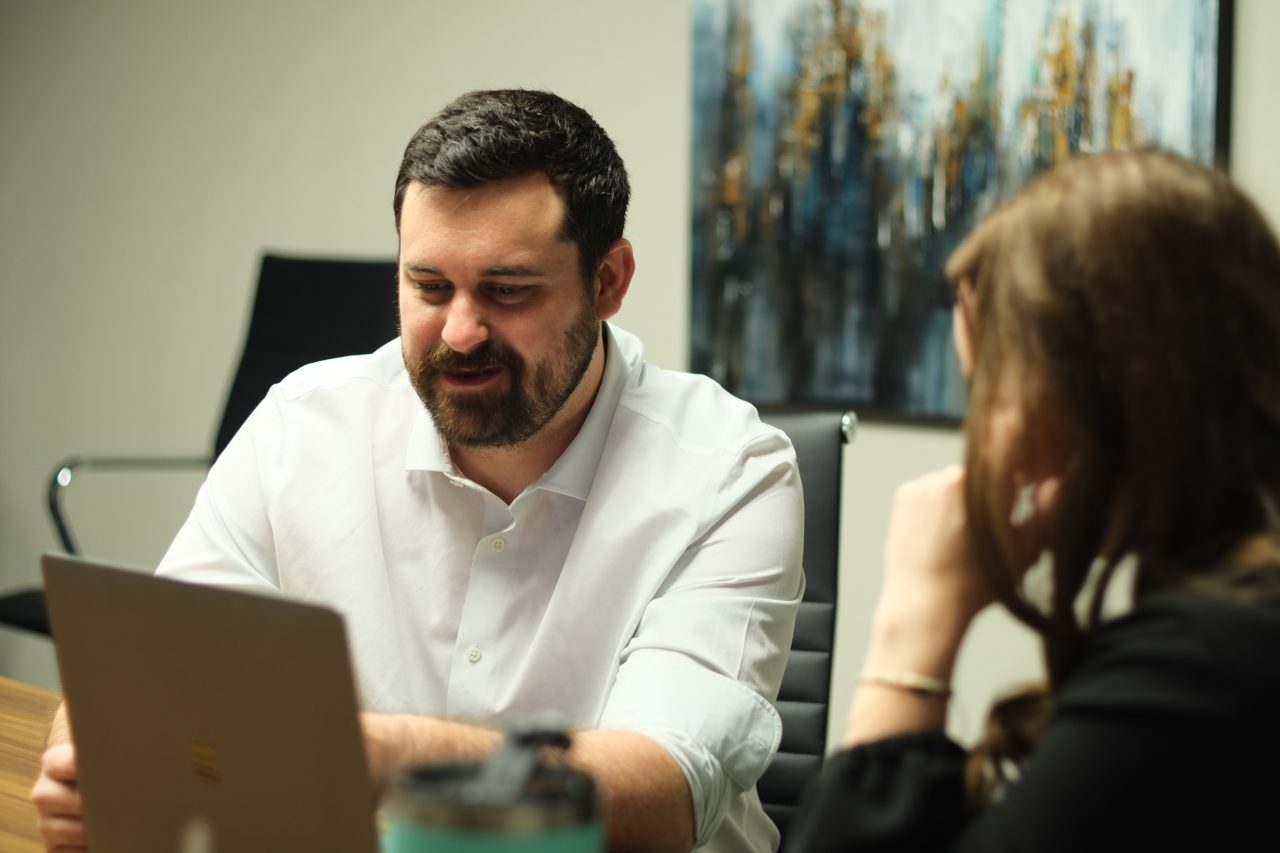 Photo of consultants talking at a computer.